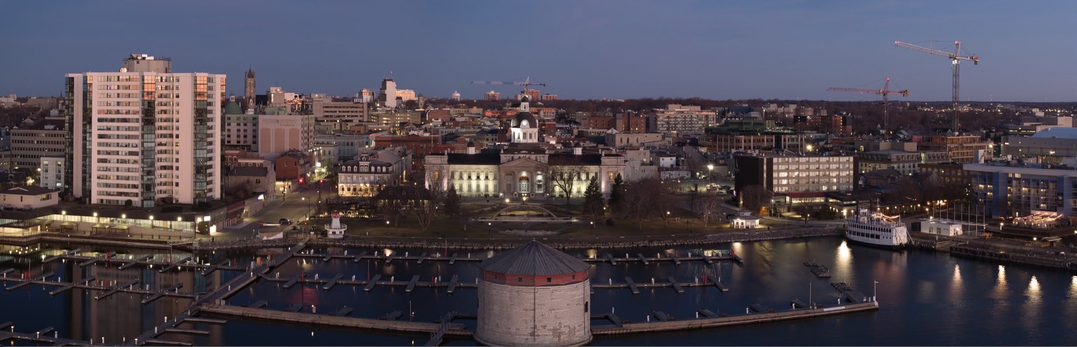 Dusk view of Kingston City Hall, the Martello tower, and the marina.